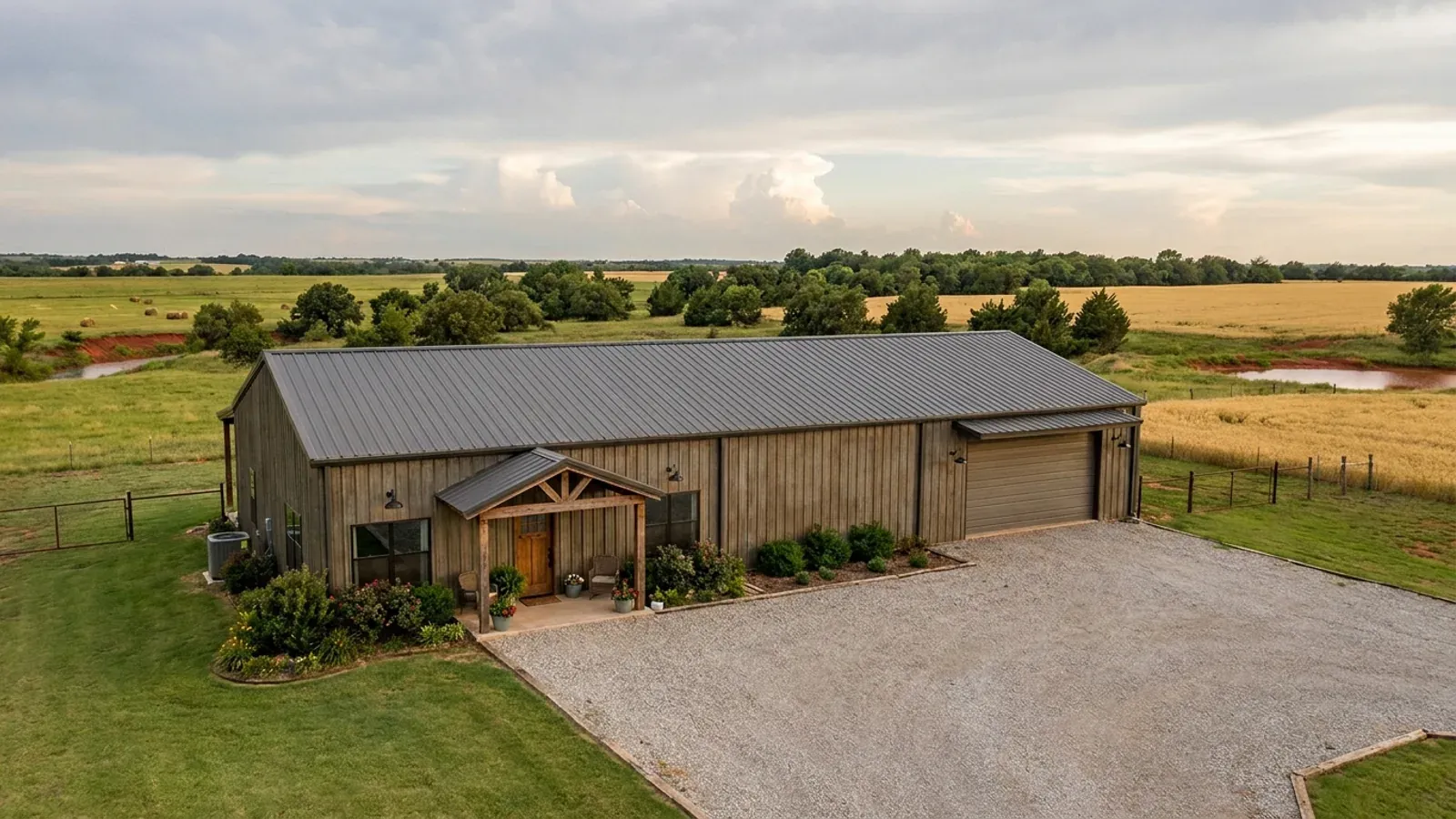 A completed 40x60 barndominium showing a residential entry on one end and a wide shop door on the other under one continuous roof.